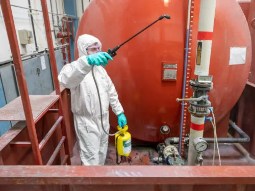 employee using LeVert chemical decontaminant on a machine to prevent chemical contamination - Preservation of equipment