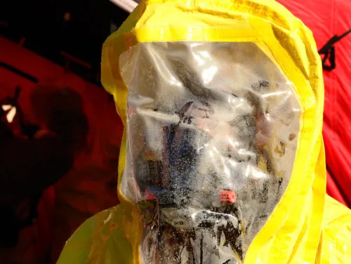employee wearing a protective suit to avoid the risk of contamination
