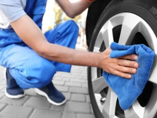 person cleaning a car wheel